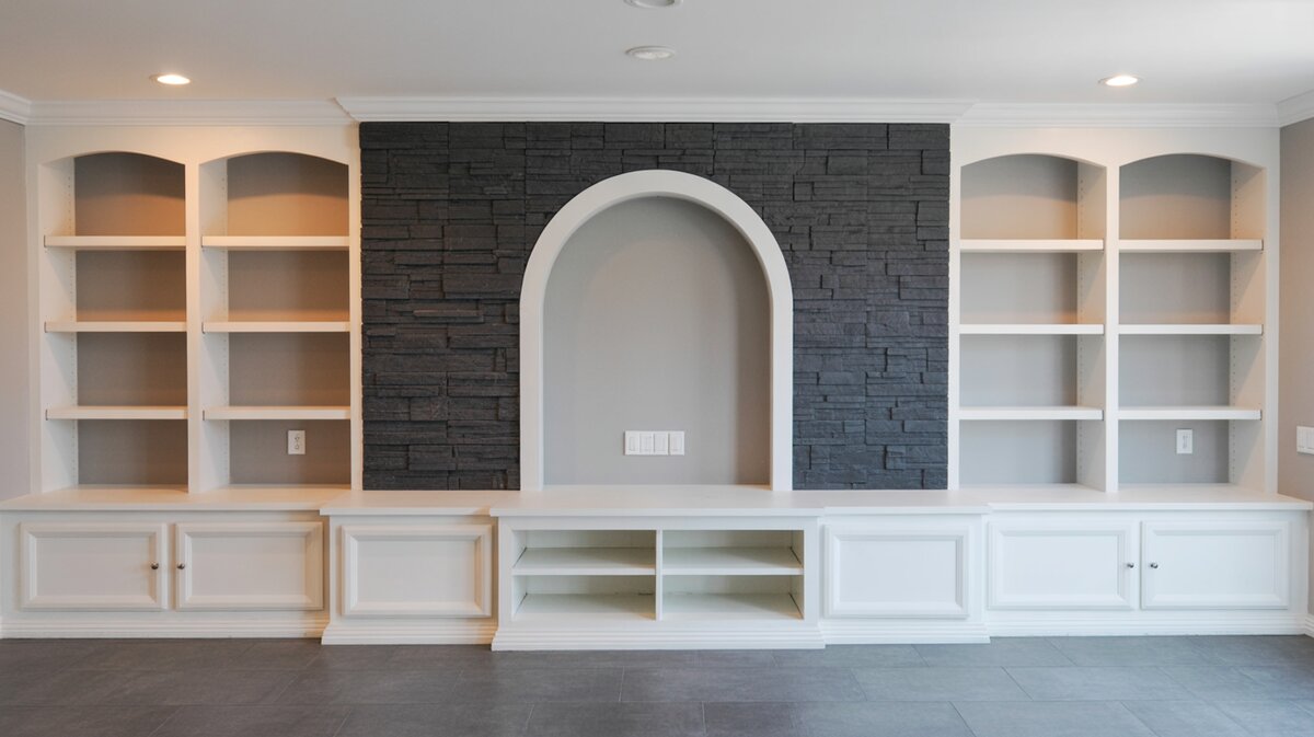 Built-in entertainment wall with dark slate stacked stone center panel and arched display niche