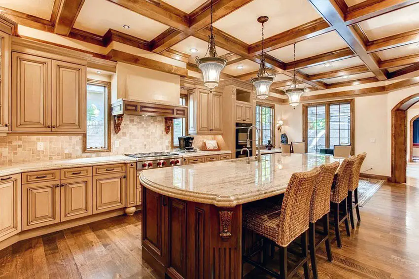 Rustic kitchen with box beam ceiling, antique cabinets, dark wood island and light granite countertops
