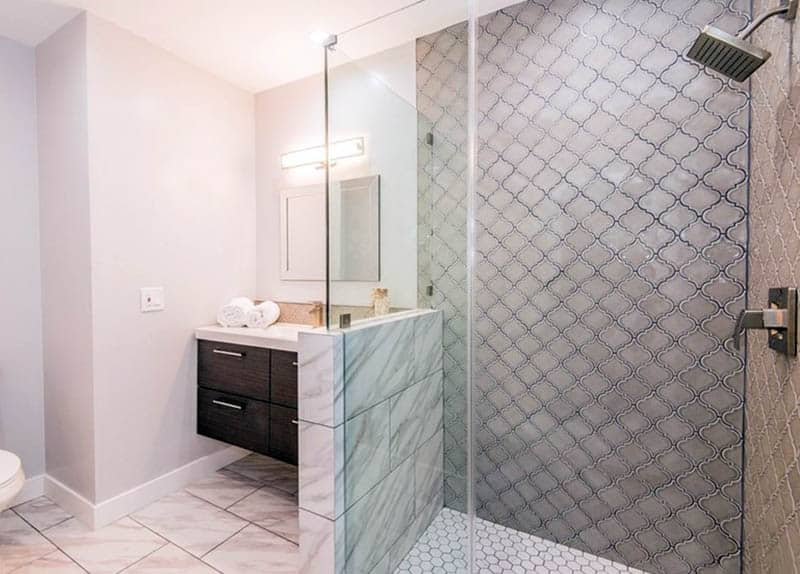 Shower with arabesque wall tiles and honeycomb patterned floors
