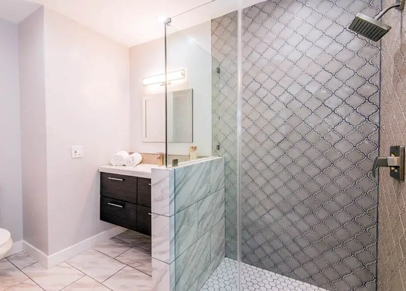 Shower with arabesque wall tiles and honeycomb patterned floors