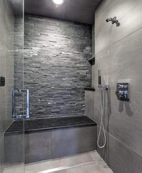 Shower with stacked stone accent wall and black granite bench seat
