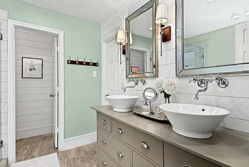 Small bathroom with green paint white shiplap and dual vessel sinks