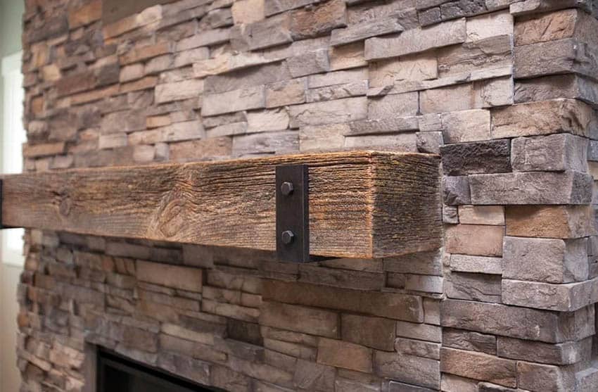Stacked stone fireplace with wood mantle
