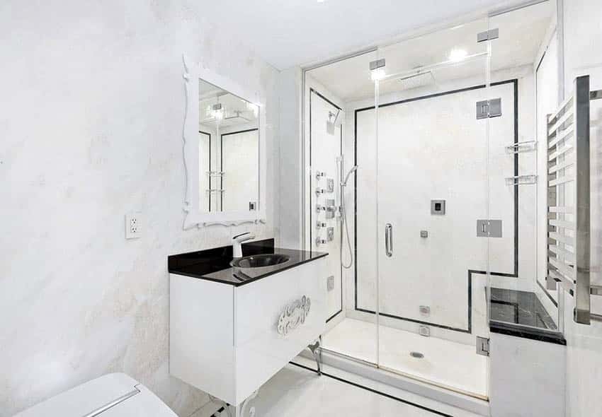 Walk in shower with white marble black granite vanity shower bench