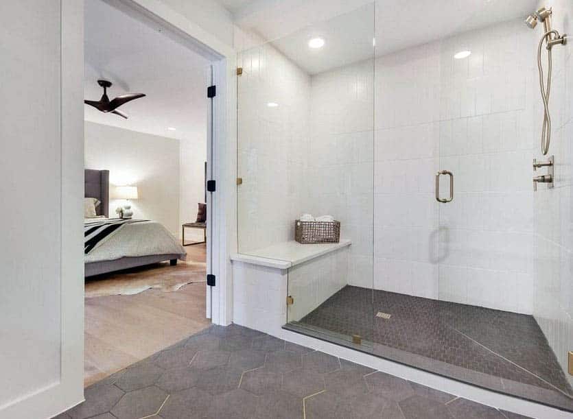 White tile walk in shower with glass door and silver finishes