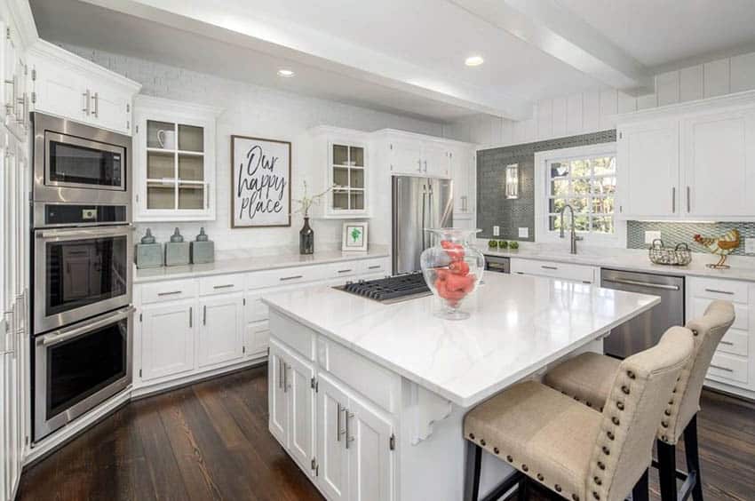 Beautiful kitchen with white shiplap walls, subway tile, marble countertops and hardwood flooring