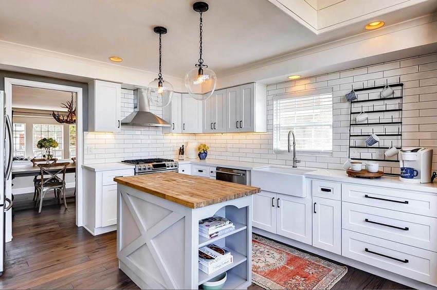 Cottage kitchen with shaker cabinets, white subway tile and black grout and butcher block island