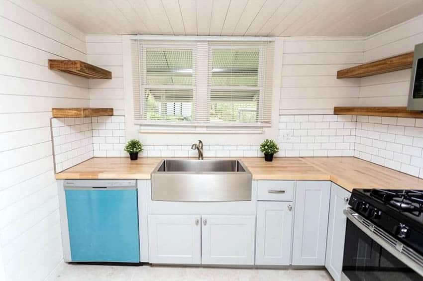 Cottage kitchen with shiplap ceiling and walls, white cabinets, wood countertops and open shelving
