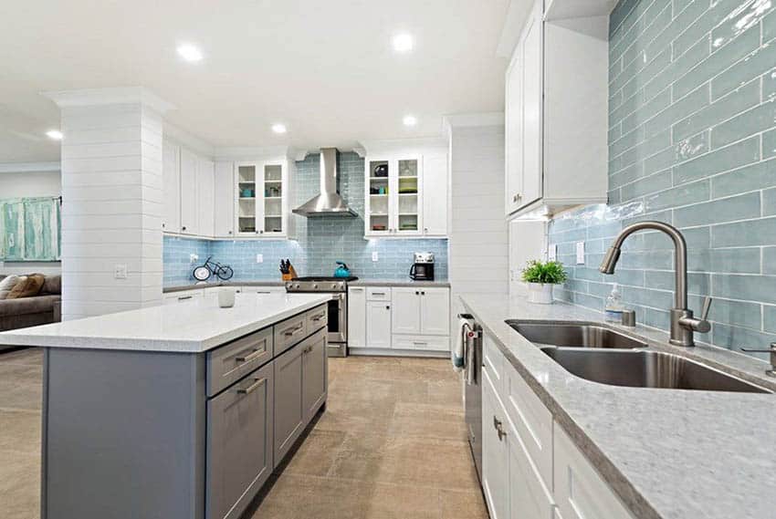 Kitchen with blue large subway tile backsplash white cabinets and gray island