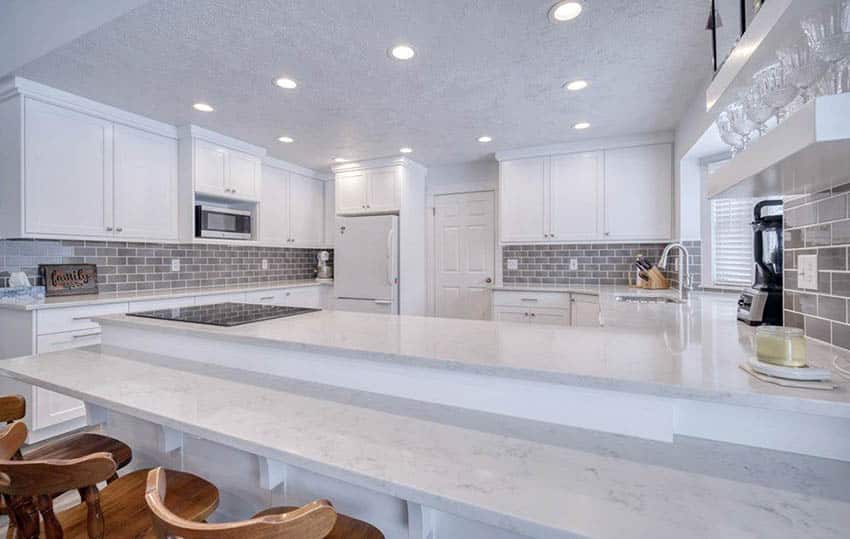 Kitchen with brown glass tile for the backsplash and brown wishbone dining chair 