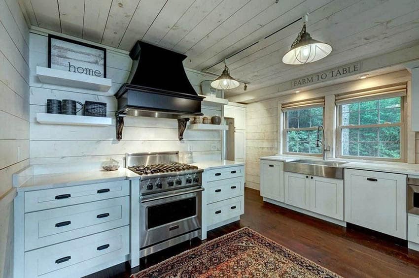 Kitchen with shiplap ceiling and backsplash, white cabinets and black range hood