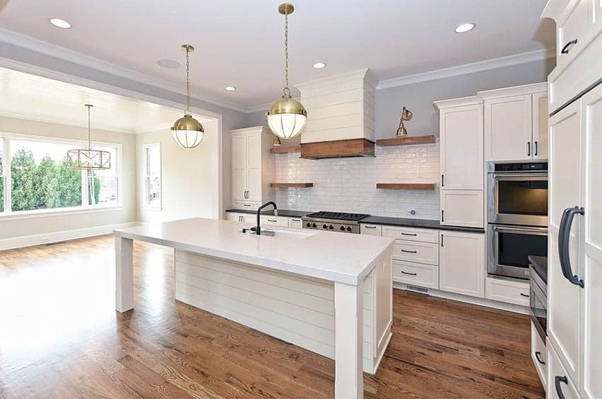 Kitchen with tongue and groove island, white cabinetry, quartz countertops and shiny tile