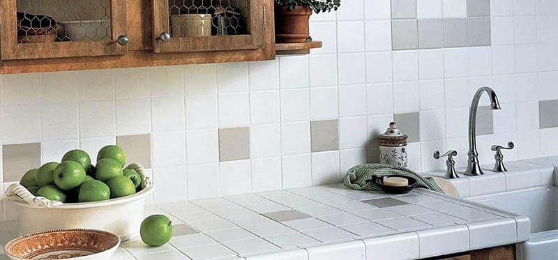 Kitchen with gray and white square tiles ans a bowl of green apples
