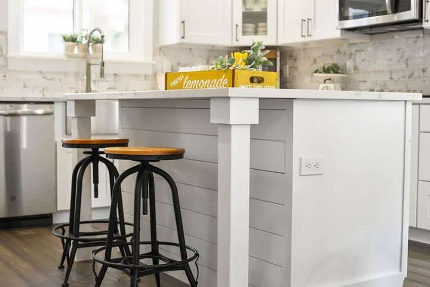 Kitchen with white shiplap island and marble stone counters