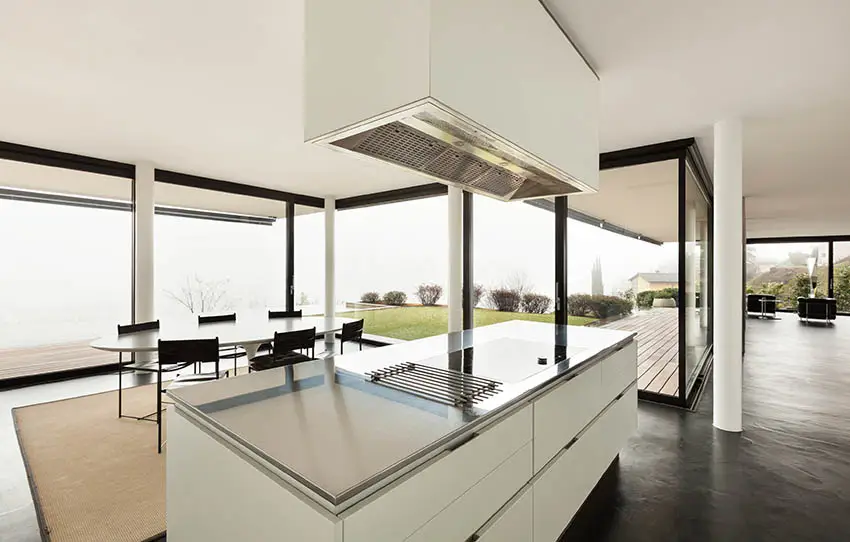 Kitchen with white island, and wraparound windows