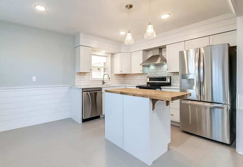 Small kitchen with butcher block island, and shiplap wainscoting 