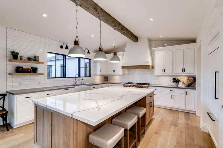 Kitchen with white tiles, quartz countertops, wood island and white cabinets