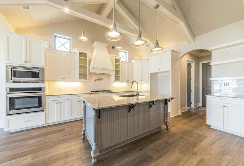 White kitchen with arched shiplap design ceiling and gray beadboard island