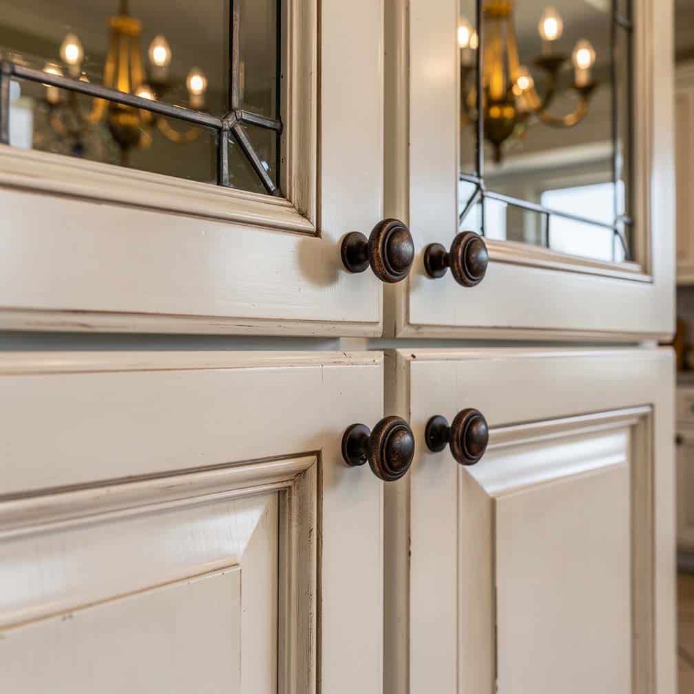 Antique white glazed kitchen cabinet doors with leaded glass inserts and oil-rubbed bronze hardware