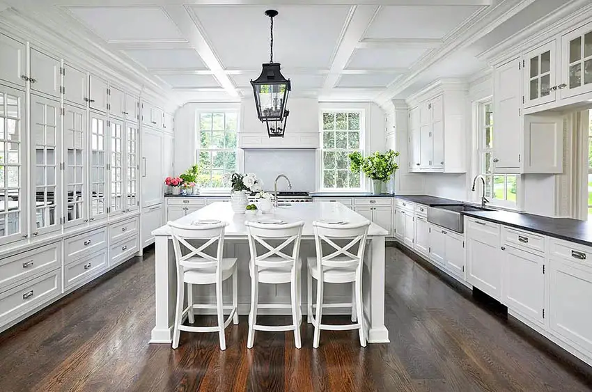 Beautiful open kitchen with black soapstone countertops white marble island and white cabinets
