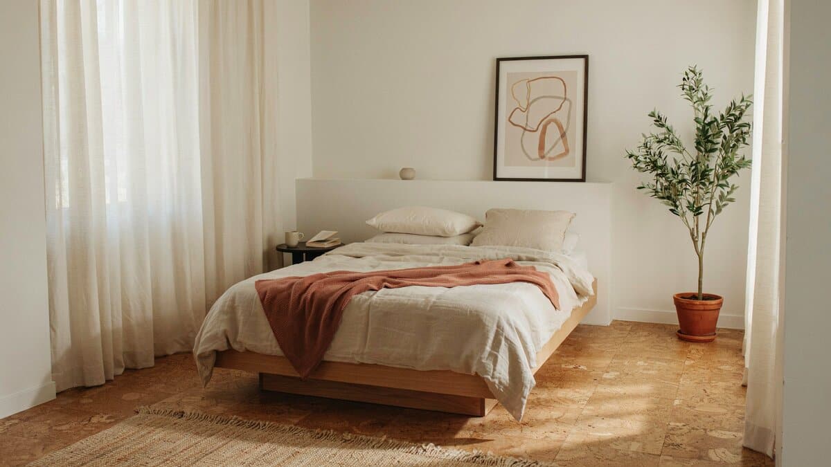 Calm bedroom with warm cork flooring and a low platform bed