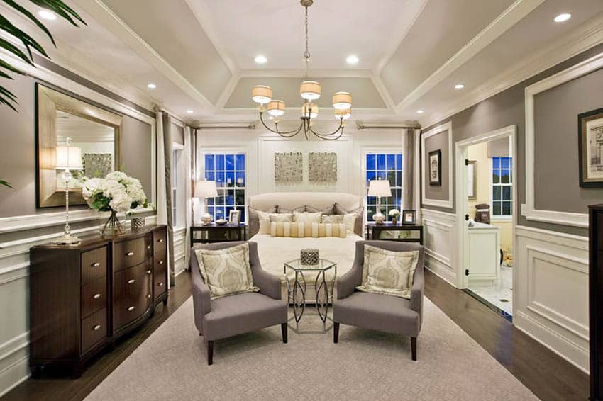 Bedroom with angled tray ceiling design, wood plank floor and wainscoting