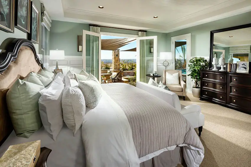 Coastal style bedroom with seafoam green paint and white wainscoting