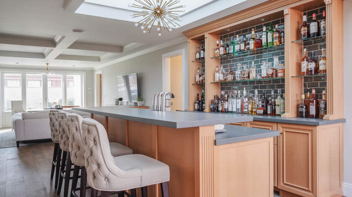 Bar with white tufted stools, gray concrete countertop, and an industrial brass chandelier