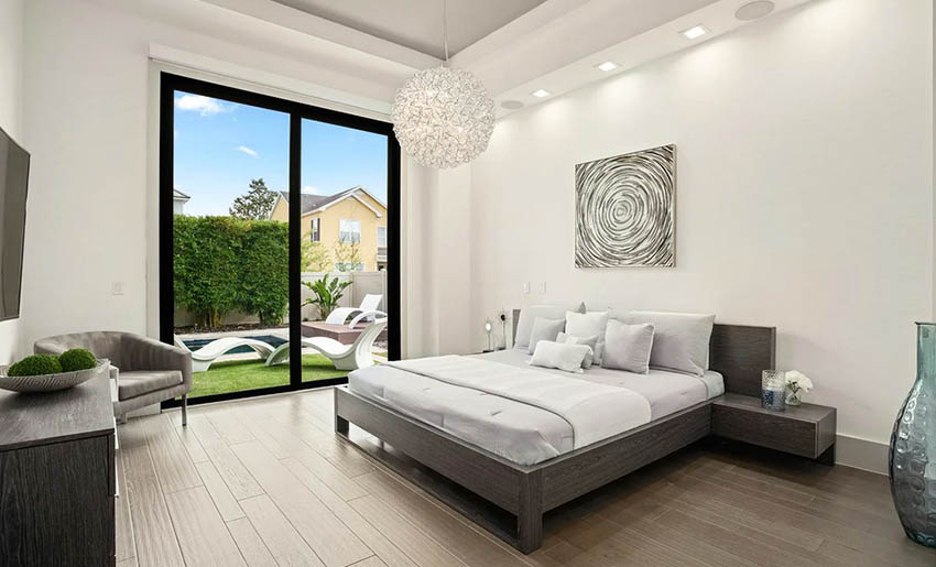Contemporary master bedroom with globe pendant light and handscraped hardwood flooring