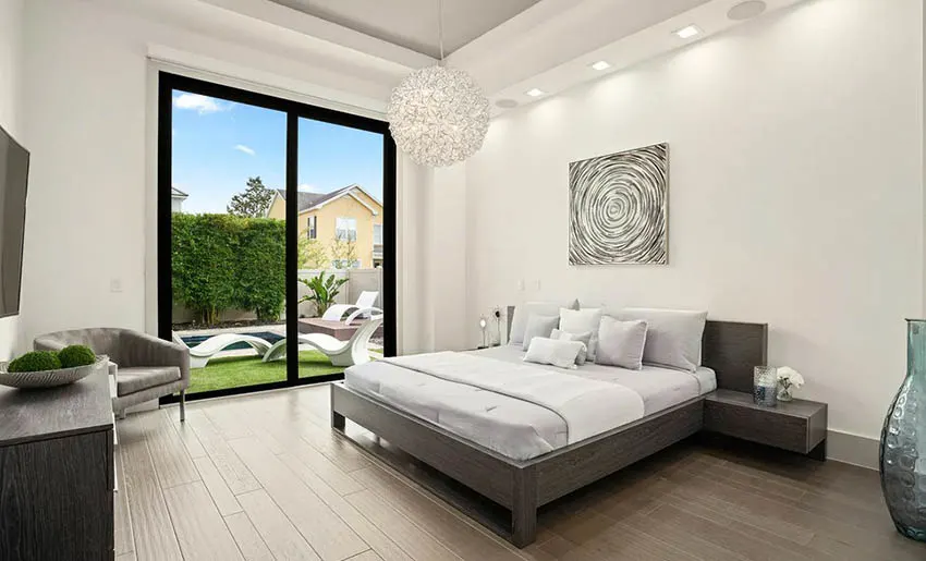 Contemporary bedroom with globe pendant light and handscraped hardwood flooring