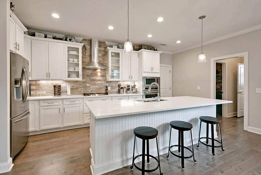 White shaker cabinets, beadboard island and quartz countertops