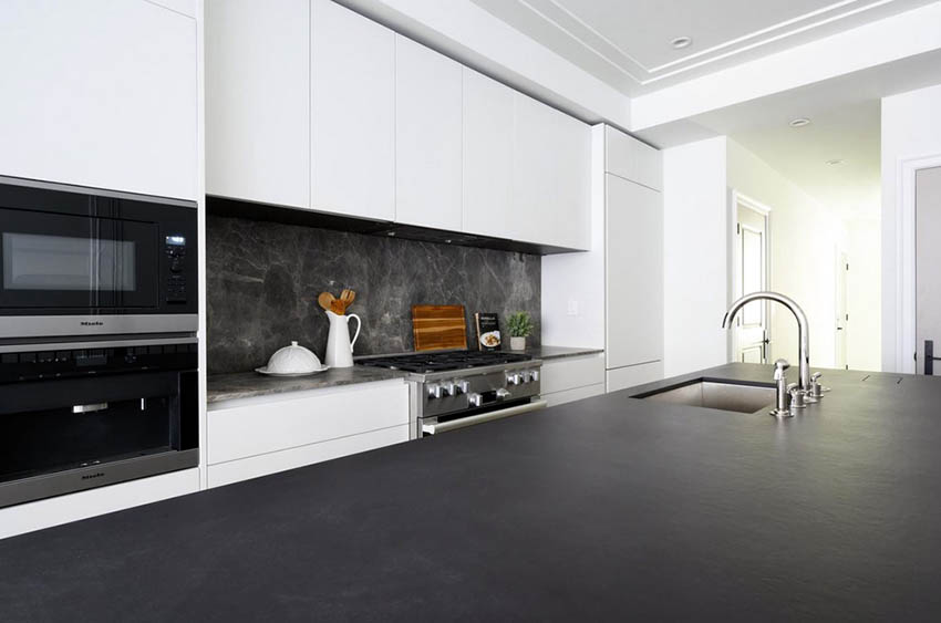 Modern kitchen with white cabinets and black leather finish quartz countertops
