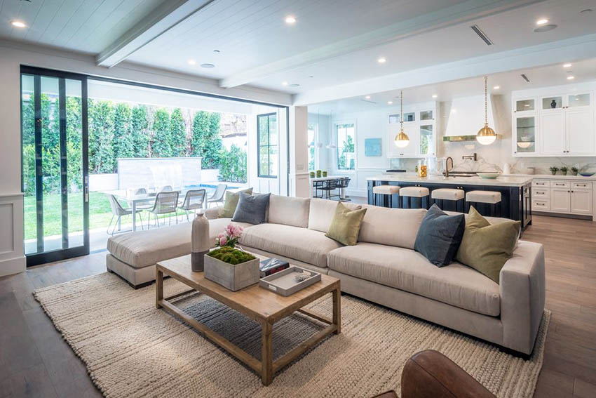 Transitional open concept living room with wainscoting and kitchen with white cabinets