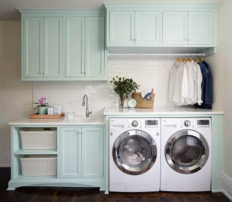 Beautiful finished laundry room with cabinets and subway tile
