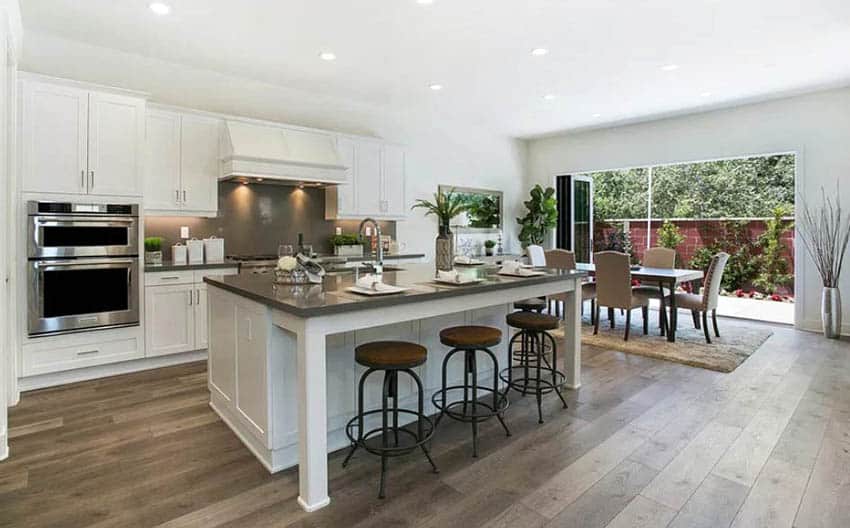 Contemporary kitchen with tongue and groove wood flooring quartz countertops and white cabinets