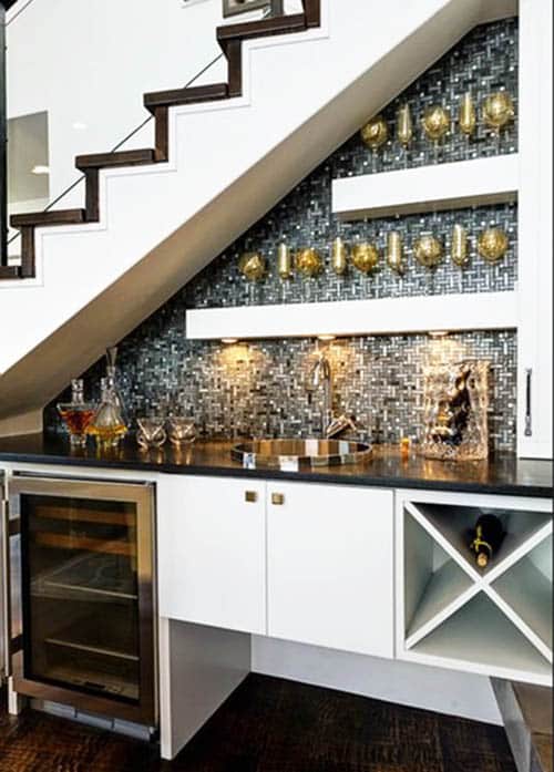 Home bar under staircase with storage, shelving, wine fridge and sink