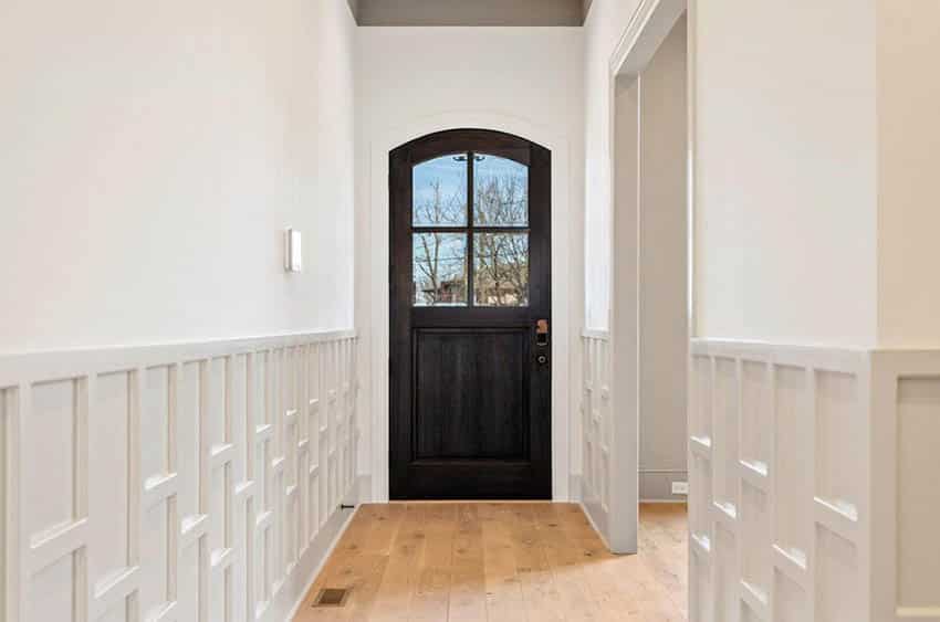 Home entryway with tongue and groove engineered wood floors and white wainscoting