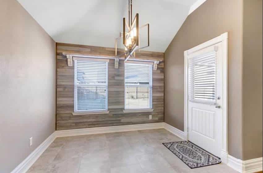 Interior with craftsman style baseboards and wood accent wall