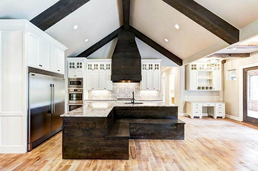 Kitchen with l shaped island with wood bench seating white cabinets