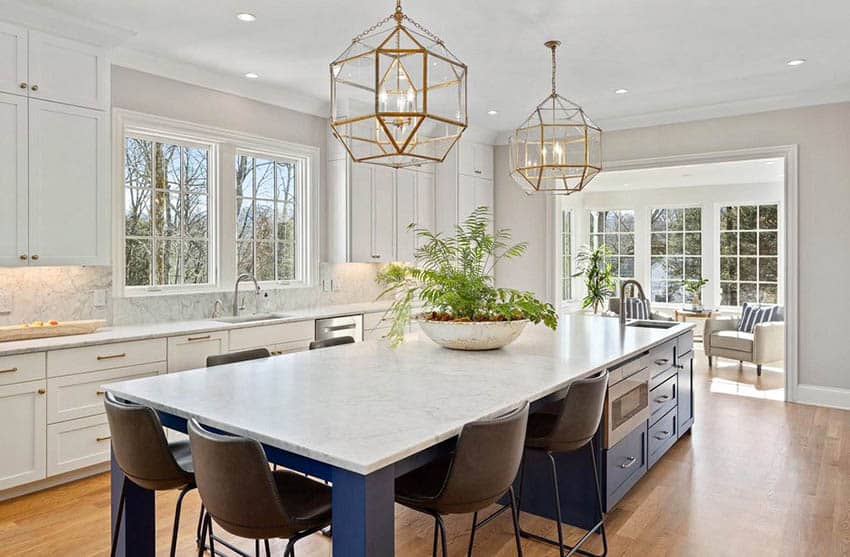 Kitchen with large island with sink gas electricity, white cupboards with gold hardware