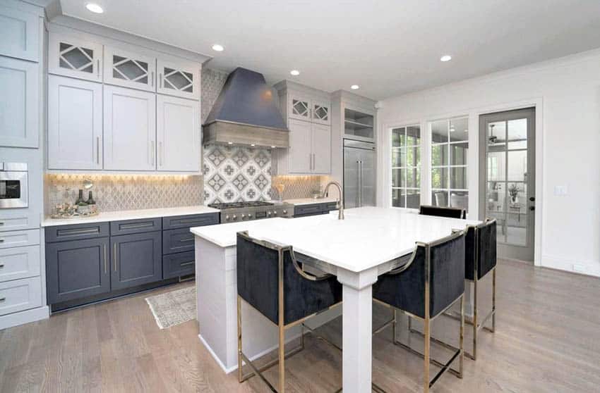 Kitchen with recessed lighting, white quartz seating island and two tone cabinets