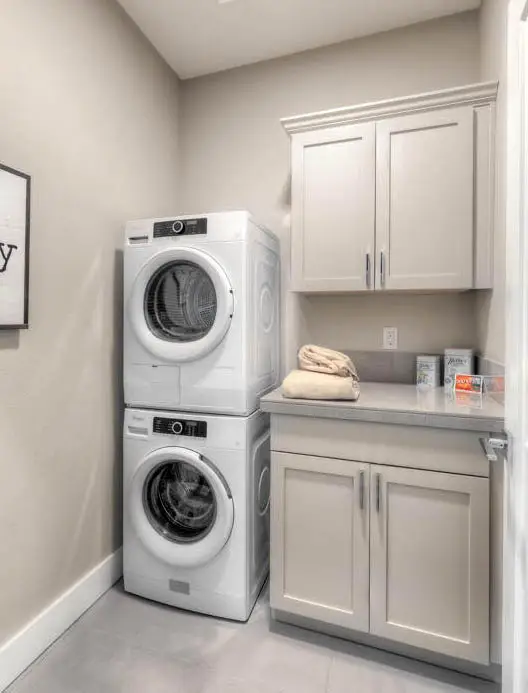 Small laundry layout with cabinet storage