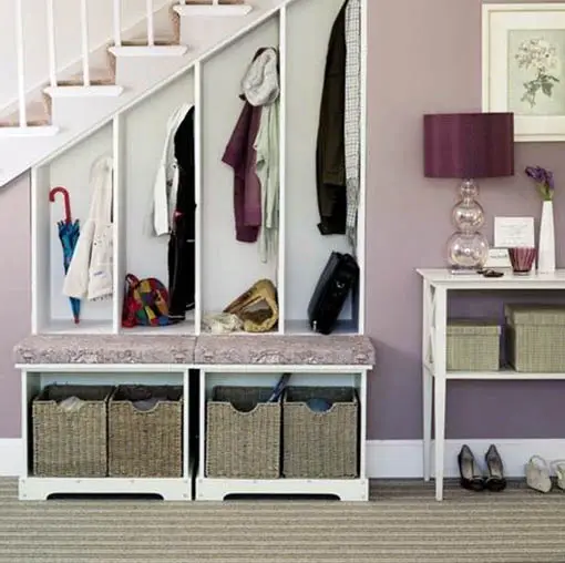 Under stairs mud room storage with coat hangers and shoe bins