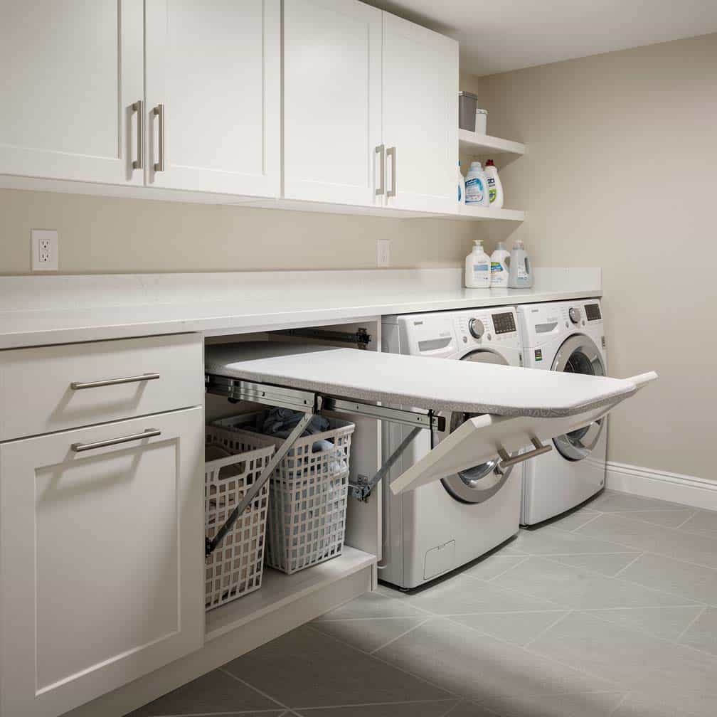Basement laundry room with a pull-out ironing board built into a cabinet drawer