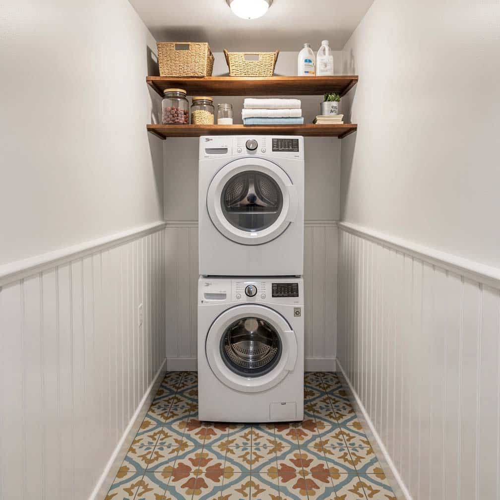 Compact basement laundry with white bead board walls and patterned cement tile floor