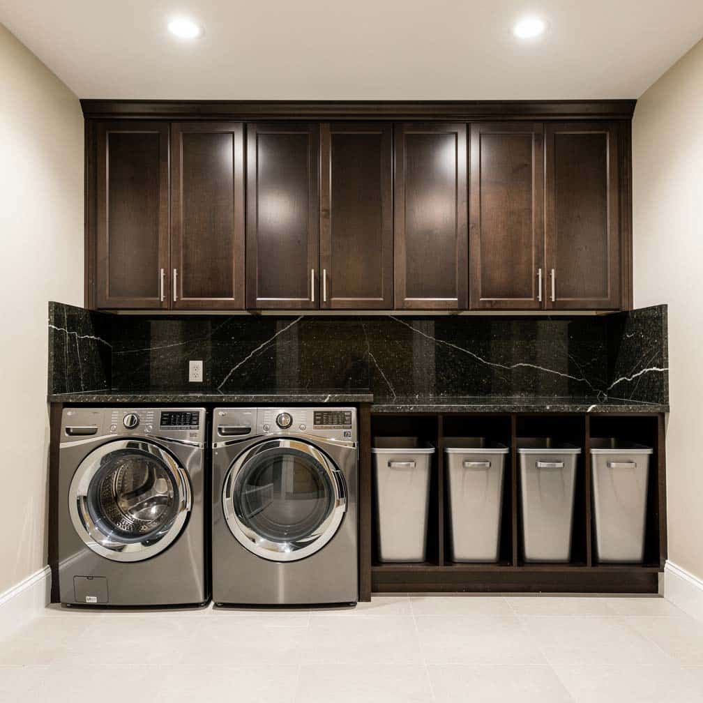 Basement laundry room with dark granite countertops over washer and dryer