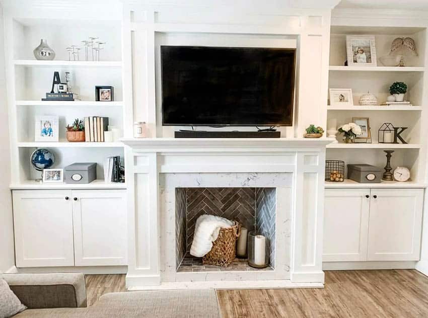 Living room with storage shelving and tv on fireplace mantel