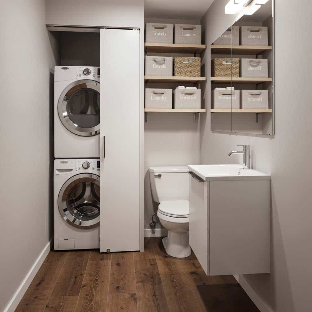 Shared basement laundry and small bathroom combo with pocket door to toilet niche