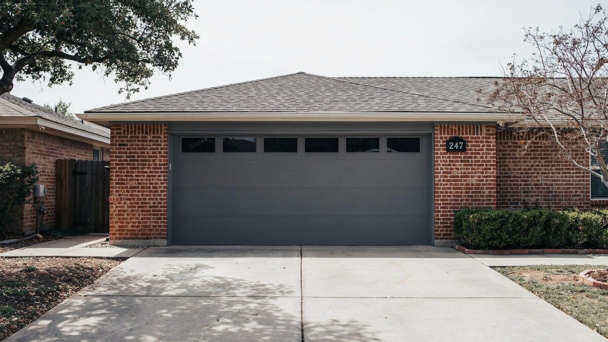 Charcoal sectional garage door topped with a row of rectangular windows