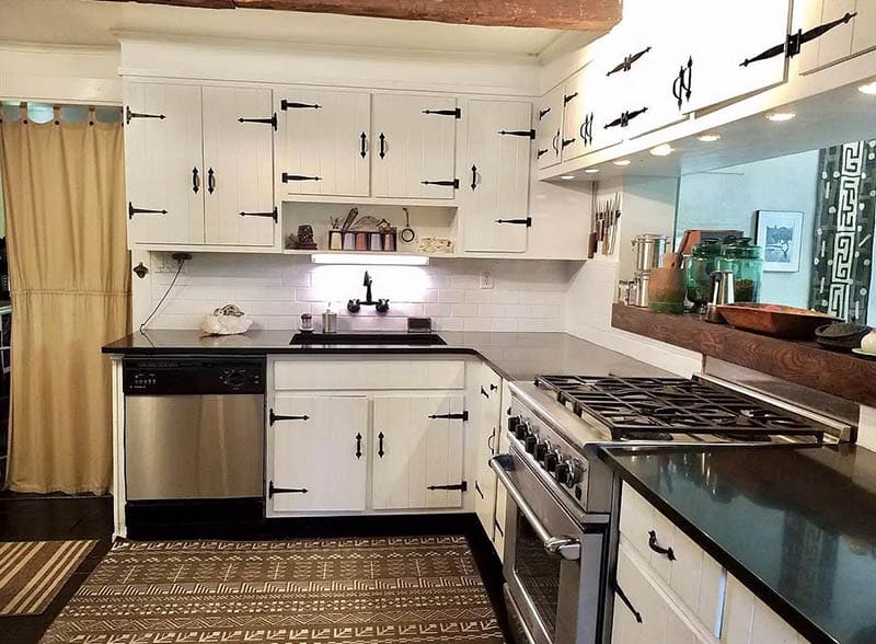 Kitchen with decorative hinges and wood slat cabinets